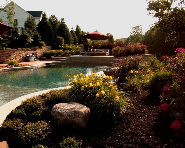 Example of a huge classic backyard stone and custom-shaped lap hot tub design