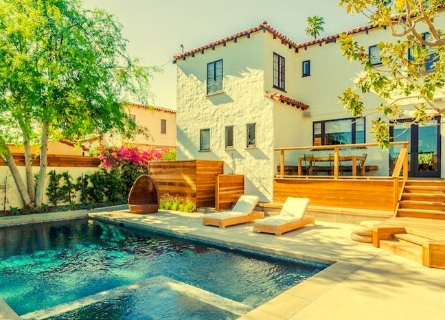 Medium-sized tuscan backyard with rectangular lap hot tub and concrete.